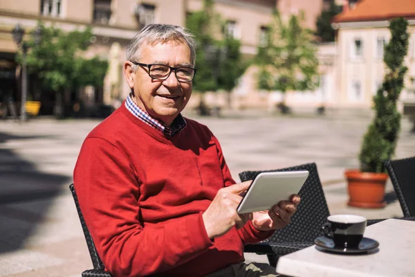 Hombre mayor usando tableta digital en el bar —  Fotos de Stock