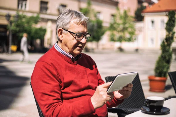 Hombre mayor usando tableta digital en el bar — Foto de Stock