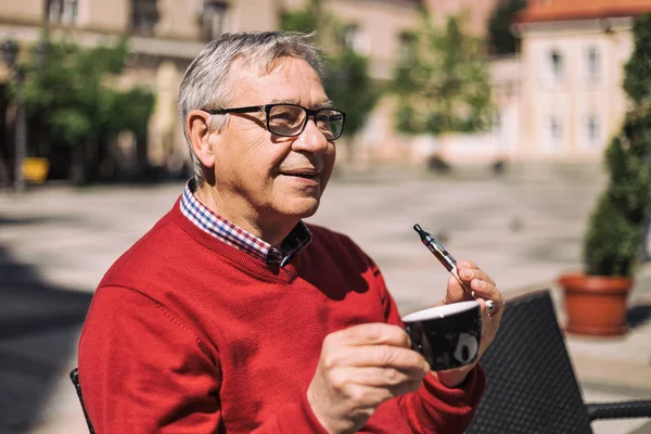 Homme âgé buvant du café et fumant cigarette électronique — Photo
