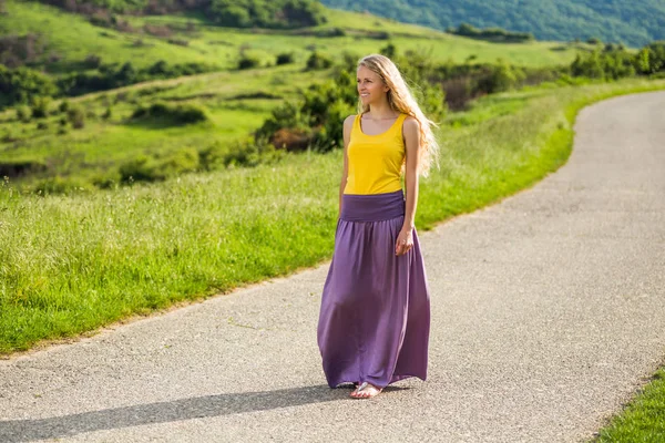 Mujer caminando por el camino del campo — Foto de Stock