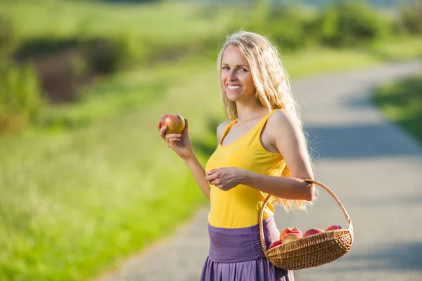 Vrouw met mand vol van appels — Stockfoto