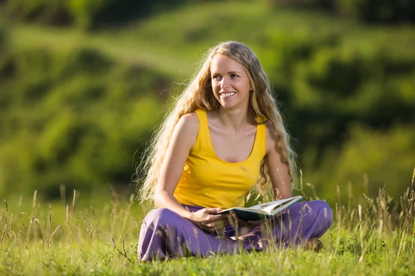 女性が草原で本を読んで — ストック写真