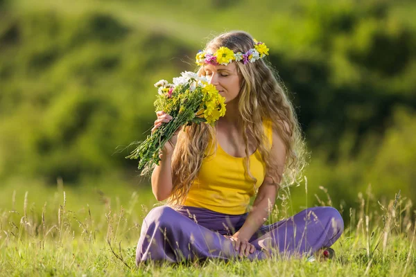 Kvinna att lukta blommor på ängen — Stockfoto