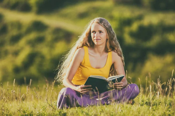 Mulher lendo livro no prado — Fotografia de Stock