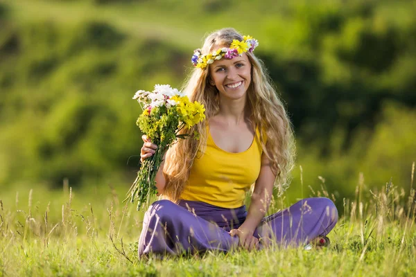 Жінка з букетом квітів на лузі — стокове фото