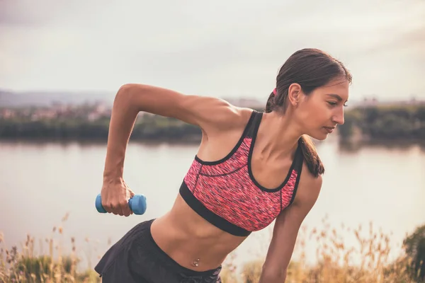 Femme sportive exerçant avec des poids — Photo