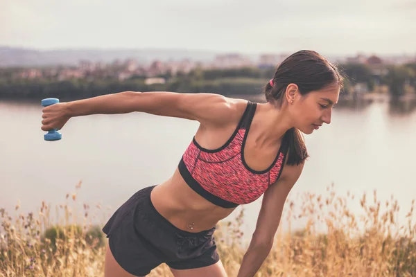 Femme sportive exerçant avec des poids — Photo