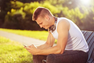 Egzersiz sonrası telefon kullanan yakışıklı adam