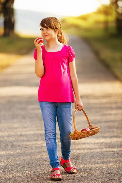 Schattig klein meisje eten apple in de natuur — Stockfoto