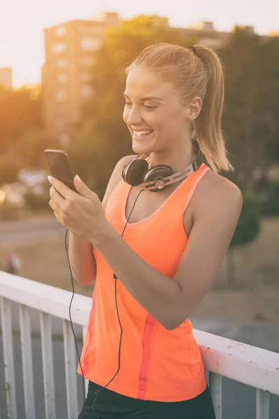 Sportig kvinna använder telefon — Stockfoto