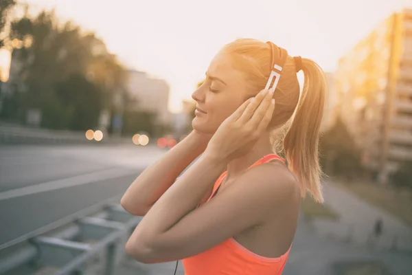 Sportieve vrouw luisteren muziek — Stockfoto