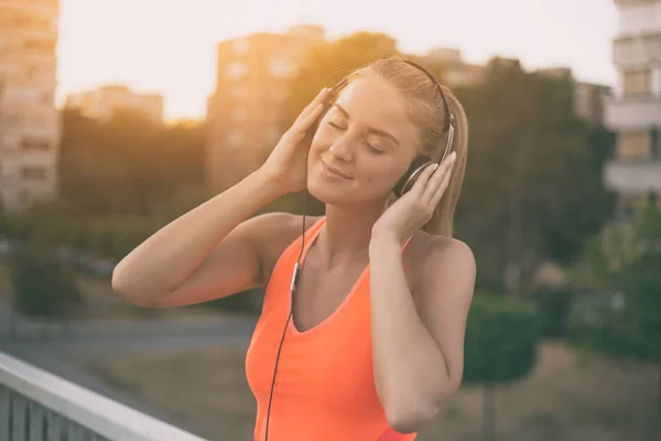 Sportieve vrouw luisteren muziek — Stockfoto
