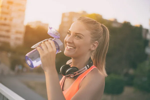 Sportiga kvinnan dricksvatten — Stockfoto