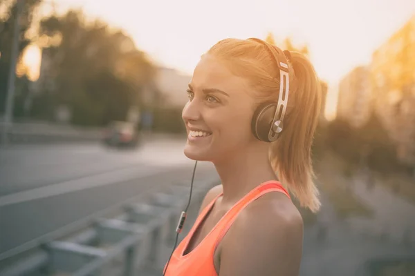 Sportiga kvinnan lyssnar musik — Stockfoto