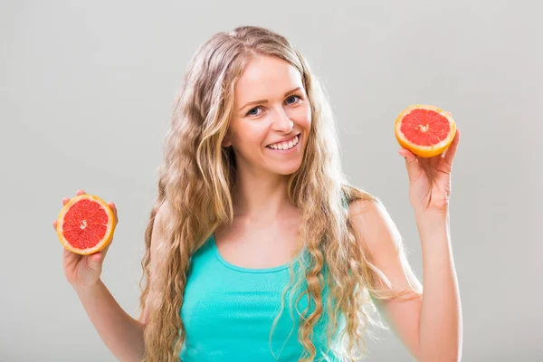 Mujer sosteniendo rodajas de pomelo — Foto de Stock