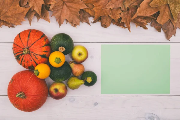 Kabak, elma, armut ve boş kağıt yaprakları ile ahşap masa üzerinde