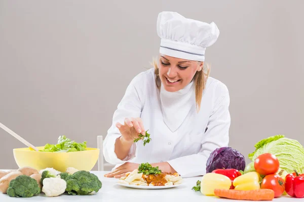 Vrouwelijke chef-kok versieren bereid maaltijd — Stockfoto