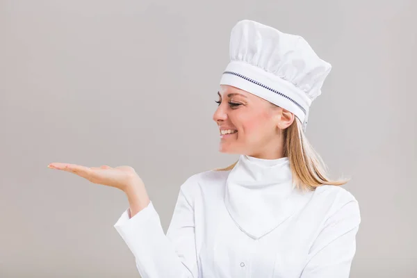 Chef hembra gesticulando sobre fondo gris — Foto de Stock