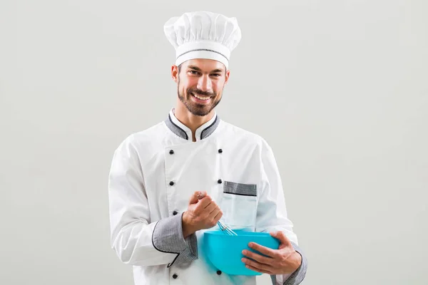 Kuchař, držící misku a drátěné šlehací metly — Stock fotografie