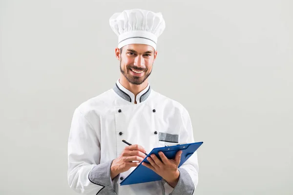 Kocken innehav kokbok och skrivande — Stockfoto