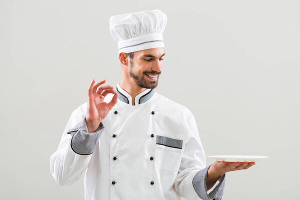 Chef with empty plate showing ok sign