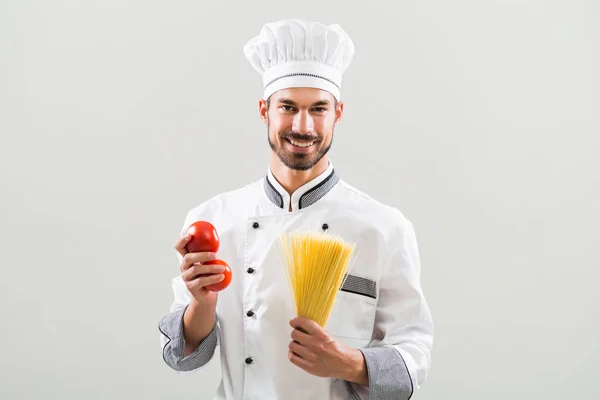 Kocken innehav tomat och spaghetti — Stockfoto