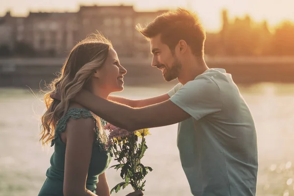 Człowiek jest dawanie kwiatów do jego dziewczyna — Zdjęcie stockowe