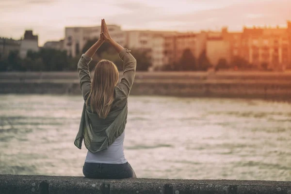 Mulher meditando na margem do rio — Fotografia de Stock