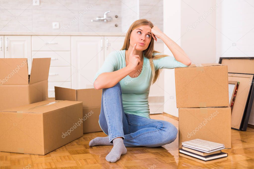 Beautiful woman is thinking about organization in her new home.