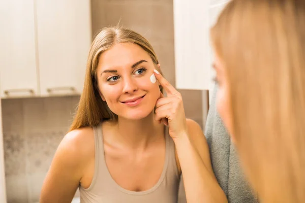 Bella Donna Che Applica Crema Idratante Sul Suo Viso — Foto Stock