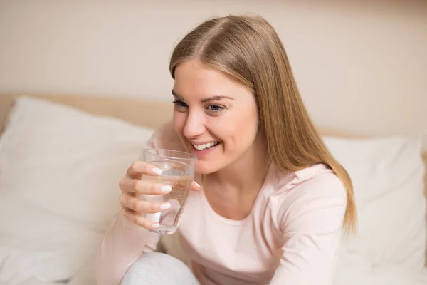 寝室のパジャマ飲料水で美しい女性 — ストック写真