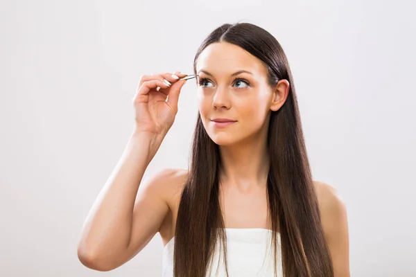 美しいブルネットの女性の眉毛を摘採のイメージ — ストック写真