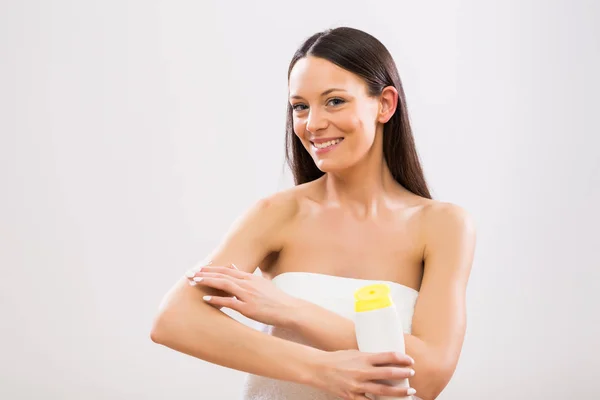 Beautiful Woman Applying Moisturizer Her Arm Gray Background — Stock Photo, Image