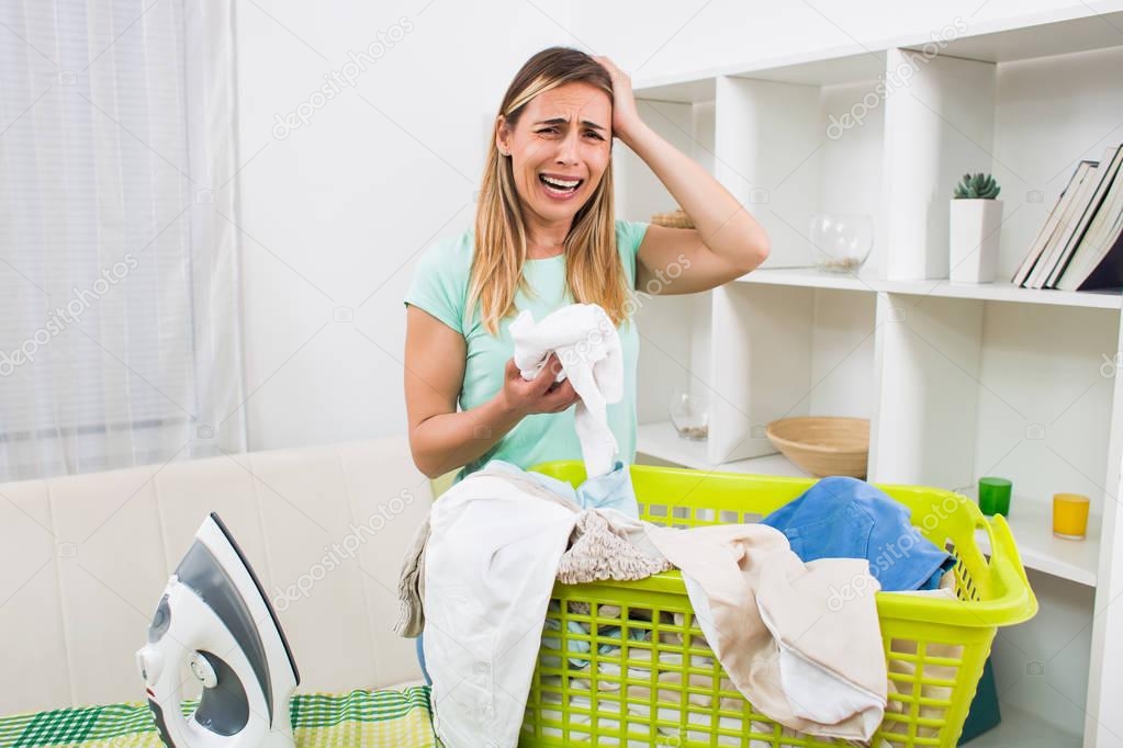 Woman is displeased because she has got to much laundry for ironing.