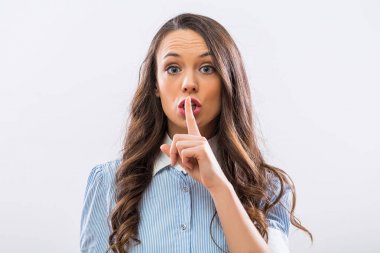 Güzel işkadını sessizlik işareti gri arka plan üzerinde gösterilen.