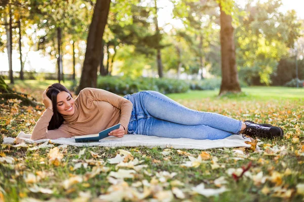 公園で本を読んで秋を楽しむ美しい女性 — ストック写真