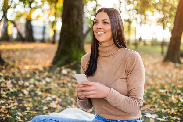 公園に座っている間に美しい女性のテキストメッセージと秋を楽しむ — ストック写真