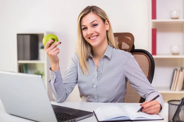 Bizneswoman Jedząc Jabłko Podczas Pracy Swoim Biurze — Zdjęcie stockowe