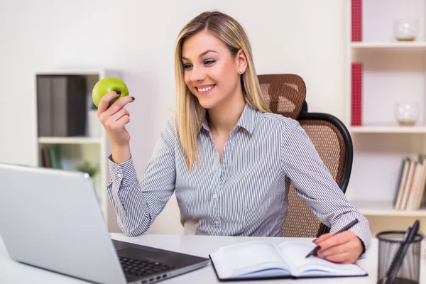 Bizneswoman Jedząc Jabłko Podczas Pracy Swoim Biurze — Zdjęcie stockowe
