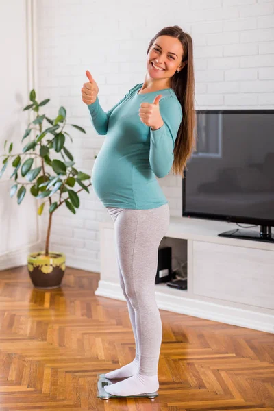 Zufriedene Schwangere Wiegt Auf Waage Und Zeigt Daumen Hoch — Stockfoto