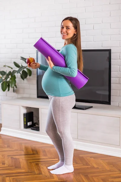 美丽的女人在怀孕期间显示出她正在健康地饮食和运动 — 图库照片
