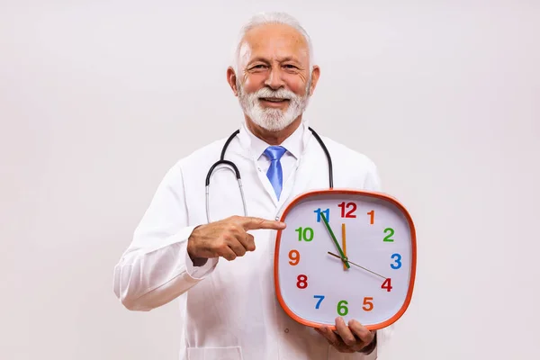 Retrato Del Médico Senior Sosteniendo Reloj Sobre Fondo Gris — Foto de Stock