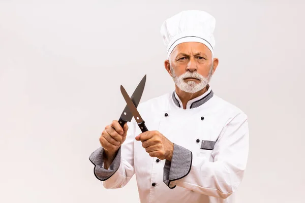 愤怒的厨师在灰色背景下磨刀的图像 — 图库照片