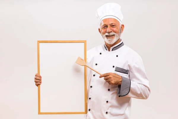 高级厨师用灰色背景的木制勺子白板展示的肖像 — 图库照片
