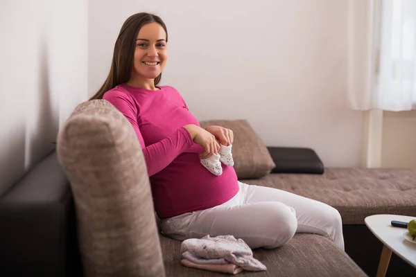 Ευτυχισμένη Έγκυος Γυναίκα Που Κρατάει Μικρές Παιδικές Κάλτσες — Φωτογραφία Αρχείου