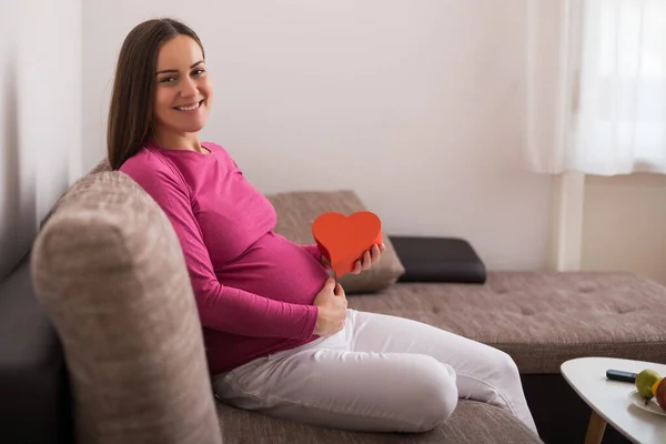 Szczęśliwa Kobieta Ciąży Trzyma Czerwony Kształt Serca — Zdjęcie stockowe