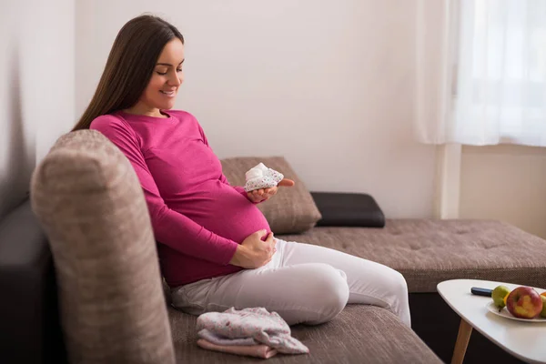 幸せな妊娠中の女性保持小さな赤ちゃんソックス — ストック写真
