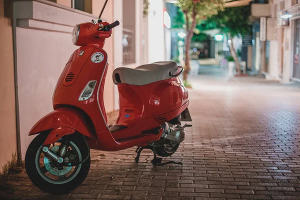 Caddeye park etmiş kırmızı scooter.