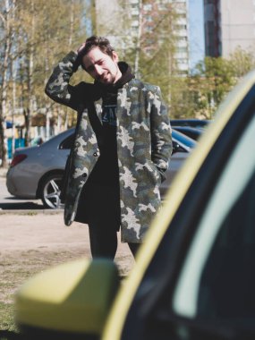 Kamuflaj ceketli genç adam.