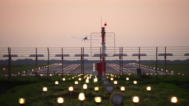オレンジ色の夕焼け空に対してシルエットの着陸飛行機 — ストック動画
